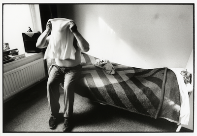 107969 Afbeelding van een thuisloze man die zich omkleedt op zijn kamer in het maatschappelijk centrum van het Leger ...